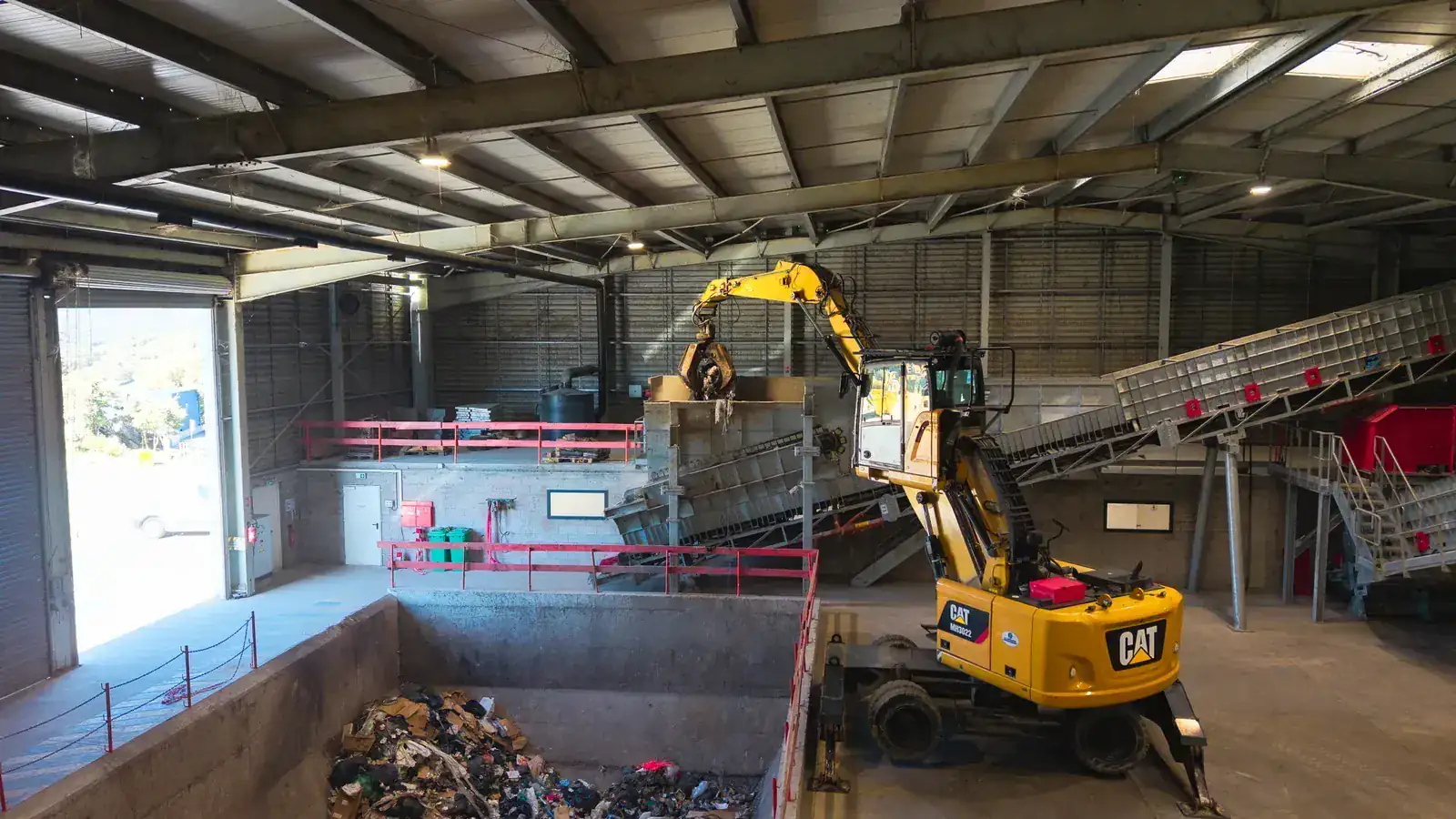 Vue intérieure du hangar de tri ISDND avec engin de manutention